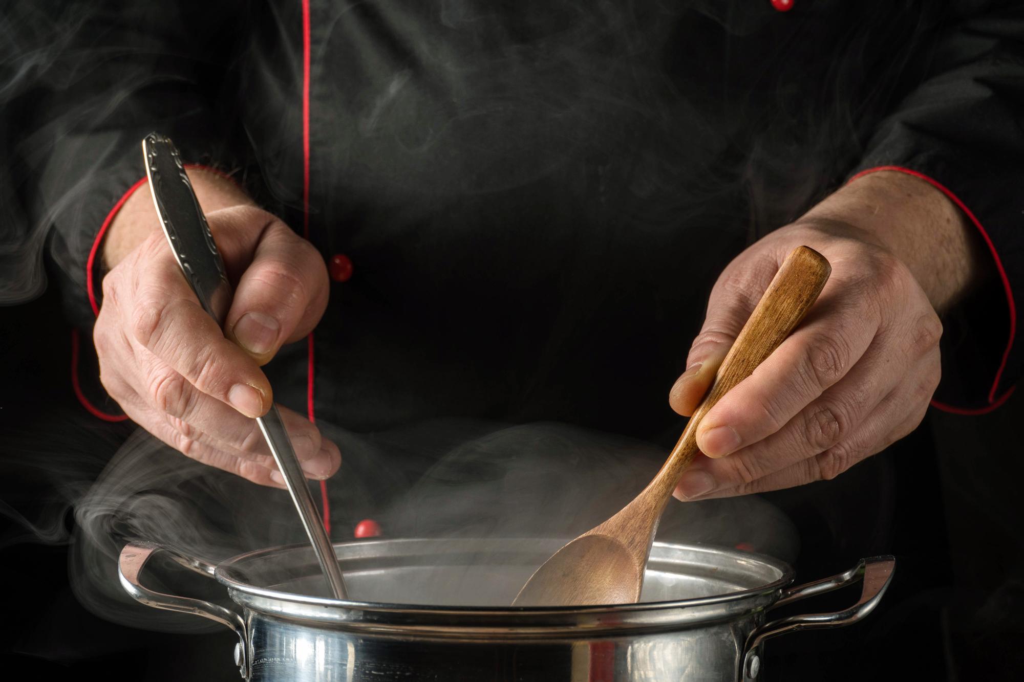 Chef seasoning artisan sauce in copper pan