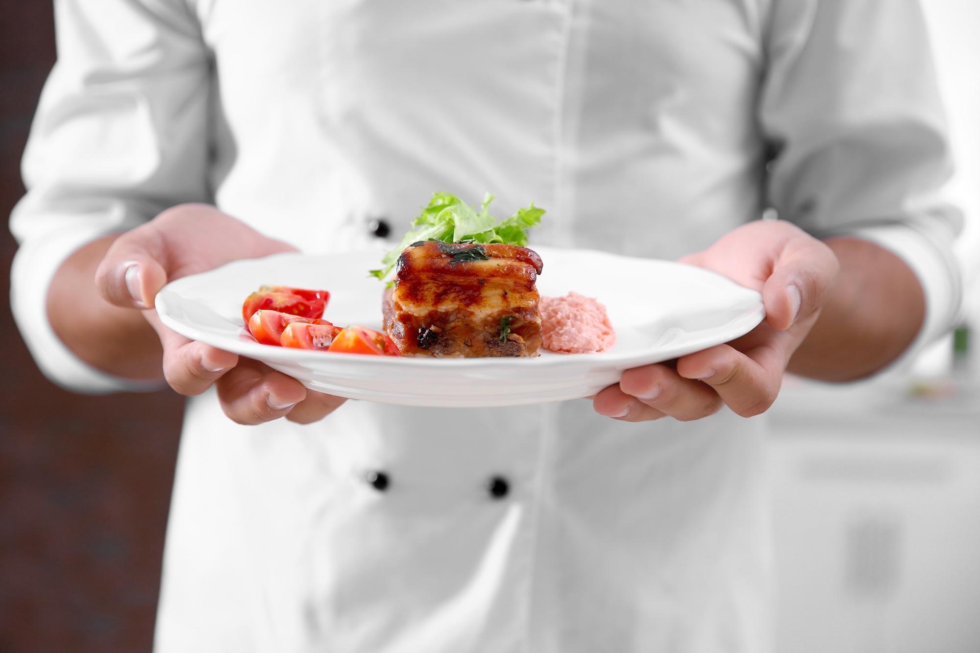 Chef bereitet traditionelles Gericht in heller Manufakturküche